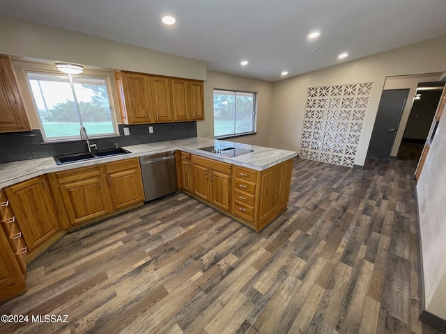 kitchen with kitchen peninsula, dark hardwood / wood-style flooring, stainless steel dishwasher, and sink