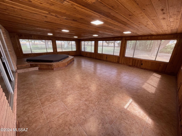 unfurnished sunroom with wood ceiling, a wealth of natural light, and a hot tub