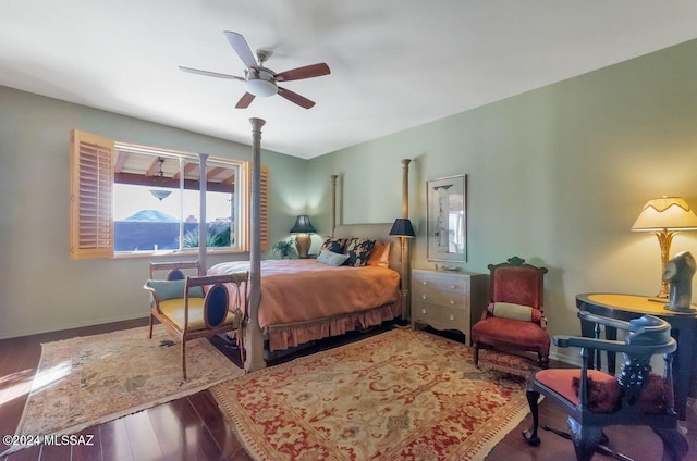 bedroom featuring ceiling fan, a mountain view, and wood-type flooring