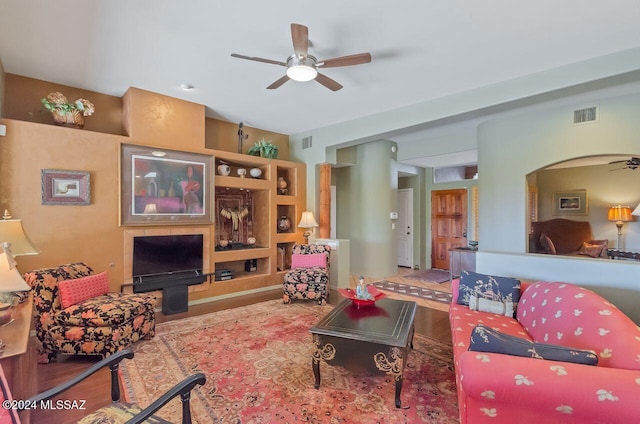 living room with ceiling fan, wood-type flooring, and built in features