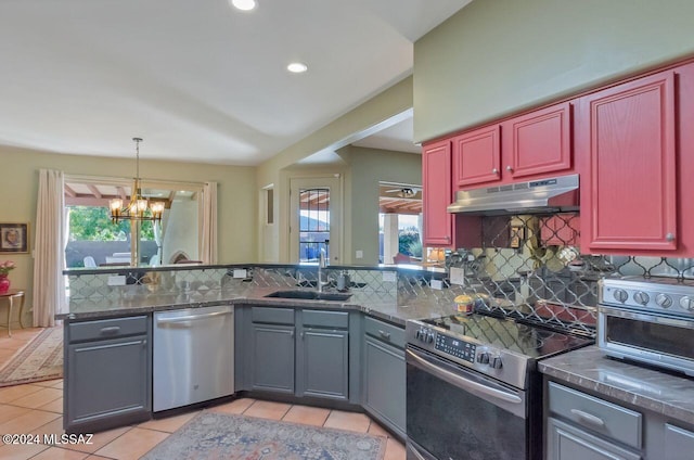 kitchen with sink, tasteful backsplash, a notable chandelier, light tile patterned flooring, and stainless steel appliances