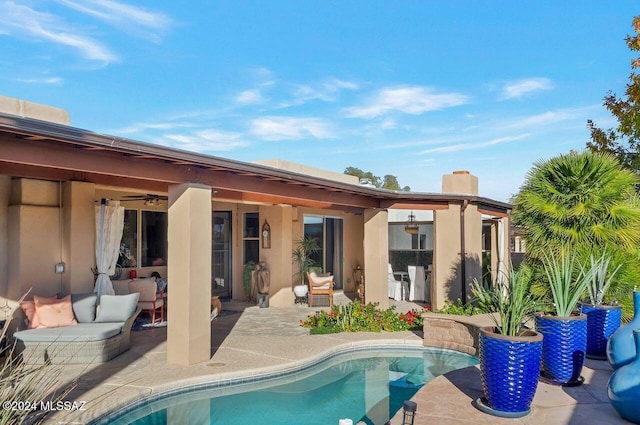 rear view of property with ceiling fan and a patio area