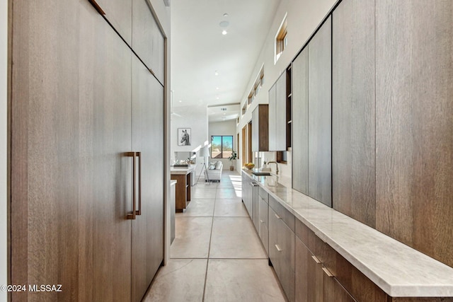 hallway with light tile patterned floors and sink