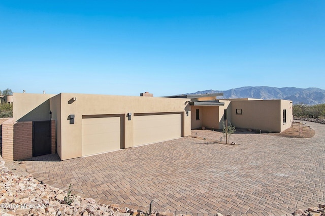 pueblo revival-style home with a mountain view and a garage