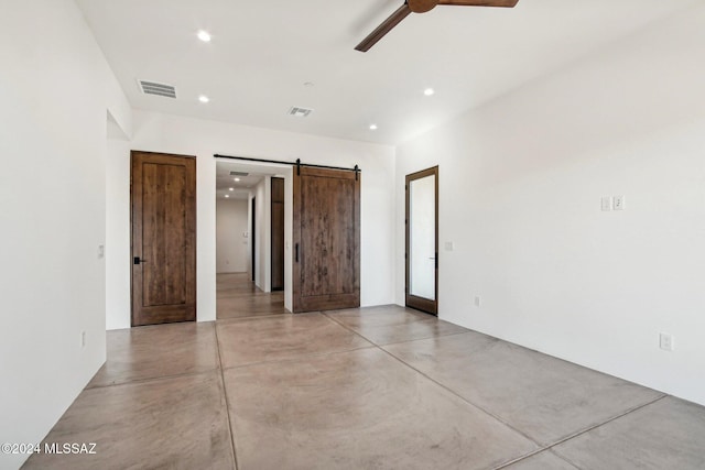 interior space featuring a barn door and ceiling fan