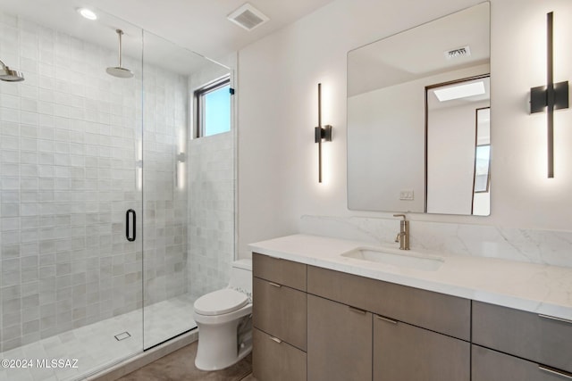 bathroom with vanity, toilet, and a shower with door