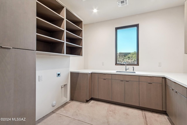 clothes washing area with electric dryer hookup and sink