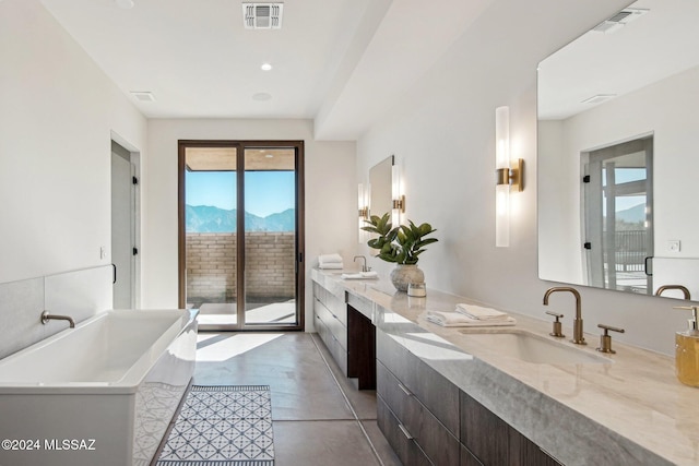 bathroom with a bathing tub, vanity, and concrete floors