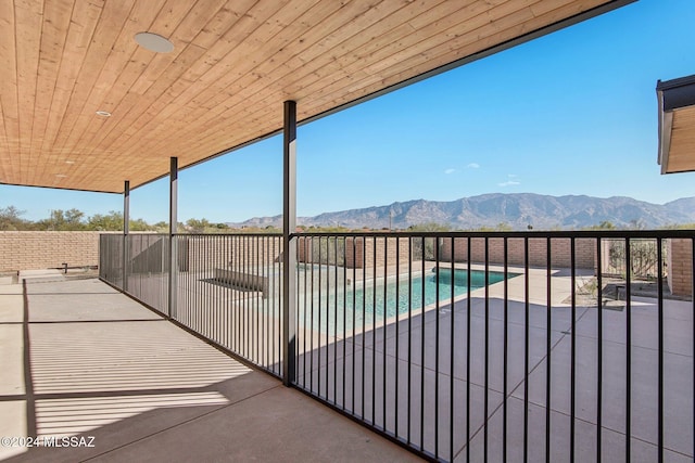 view of patio with a mountain view and a fenced in pool