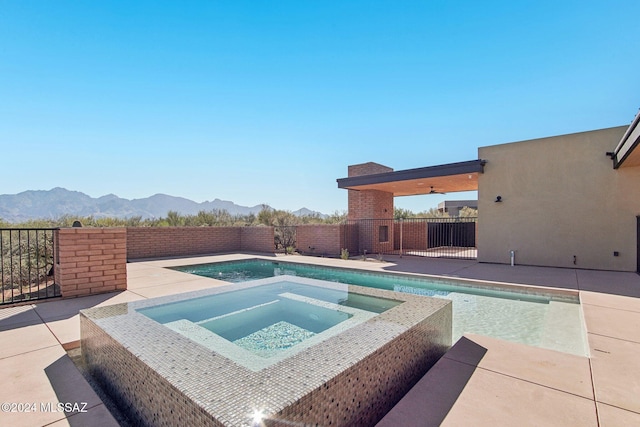 view of pool featuring a mountain view, ceiling fan, an in ground hot tub, and a patio