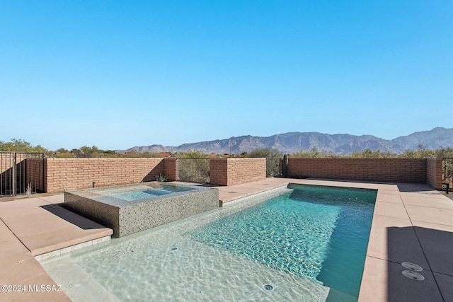 view of swimming pool featuring a mountain view and an in ground hot tub