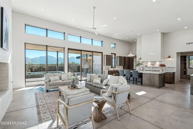 living room featuring a mountain view, a high ceiling, and ceiling fan