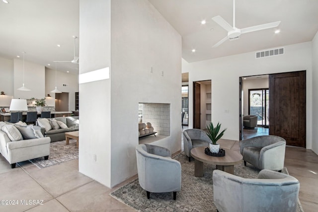 living room with ceiling fan and a towering ceiling