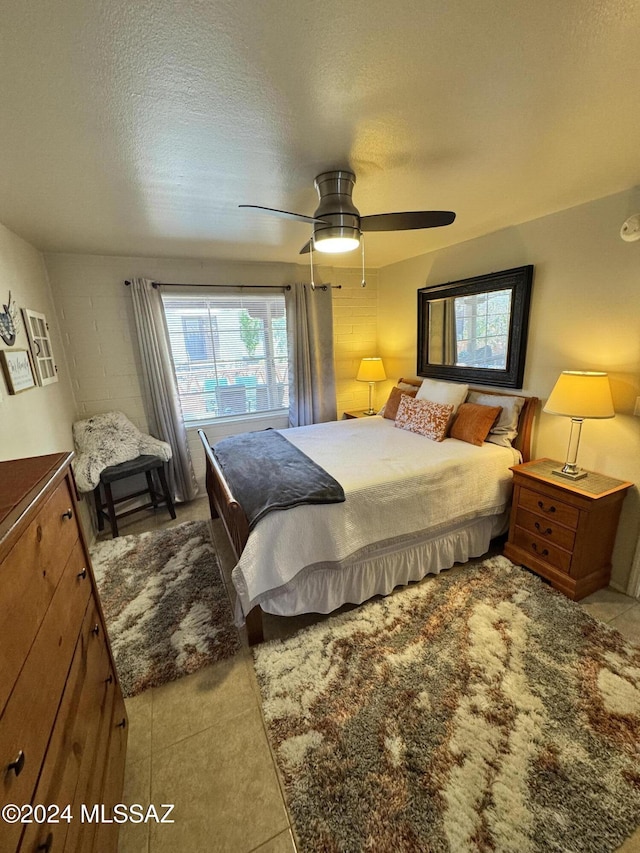 bedroom featuring a textured ceiling, ceiling fan, and light tile patterned flooring