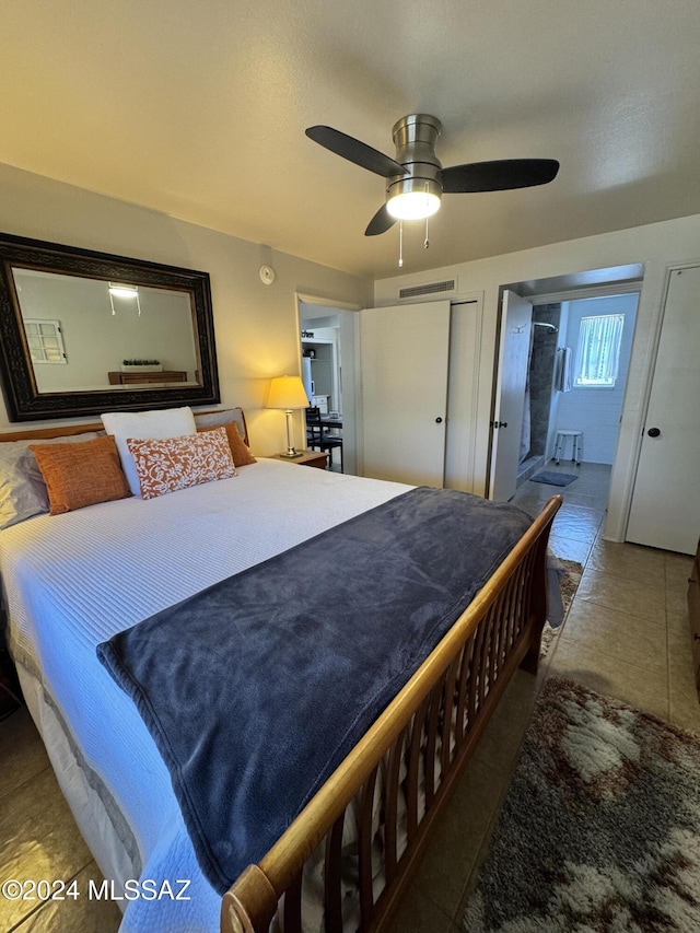 bedroom with connected bathroom, ceiling fan, and dark tile patterned flooring