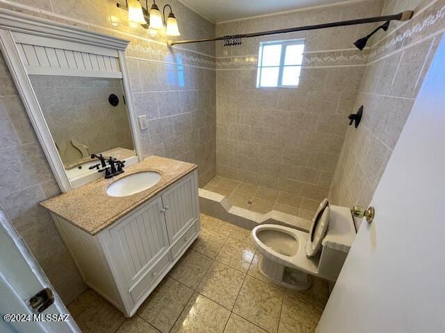 bathroom featuring vanity, decorative backsplash, tile walls, and tiled shower