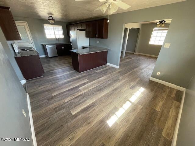 kitchen with dishwasher, dark wood-type flooring, white fridge, a textured ceiling, and dark brown cabinets