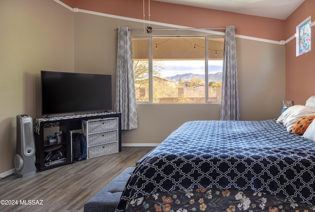 bedroom with wood-type flooring and multiple windows