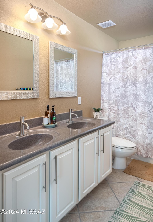 bathroom featuring toilet, a textured ceiling, vanity, and tile patterned floors