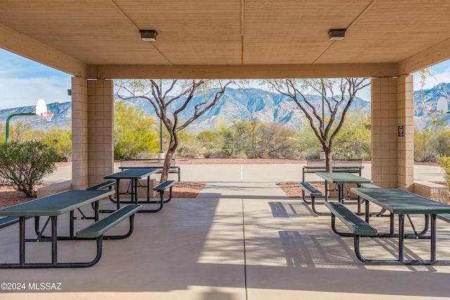 view of patio featuring a mountain view and basketball hoop