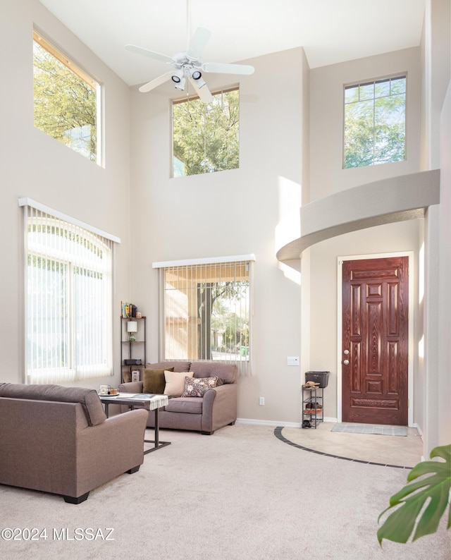 living room with carpet flooring, plenty of natural light, and a towering ceiling