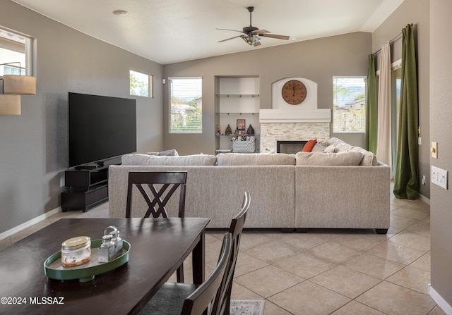 living room with a fireplace, ceiling fan, lofted ceiling, and light tile patterned flooring