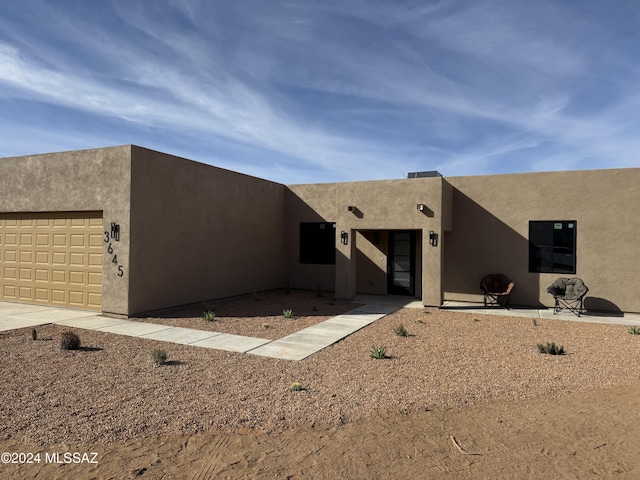 pueblo revival-style home featuring a garage