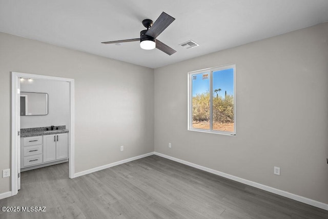 unfurnished bedroom with ceiling fan, sink, and light hardwood / wood-style floors