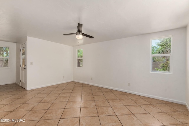 empty room with ceiling fan and light tile patterned floors