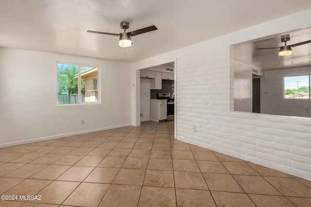 tiled spare room with ceiling fan