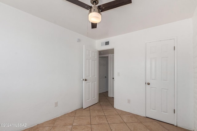 unfurnished bedroom featuring ceiling fan and light tile patterned floors