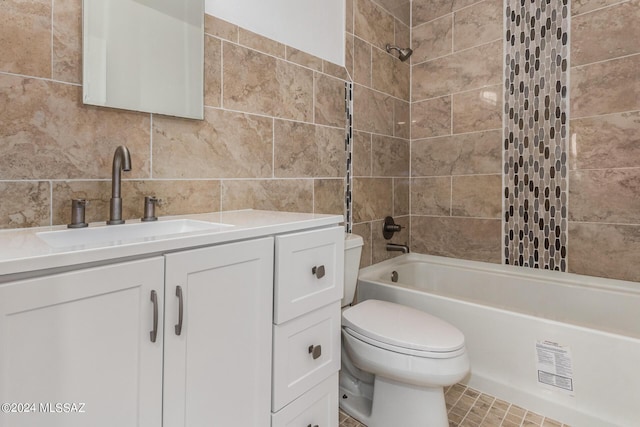 full bathroom with tiled shower / bath combo, backsplash, tile patterned floors, vanity, and tile walls