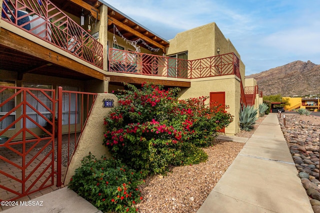 view of side of property featuring a mountain view and a balcony