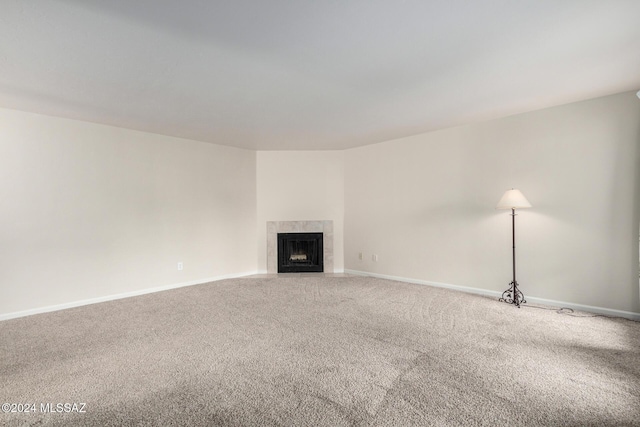 unfurnished living room featuring a tiled fireplace and carpet floors