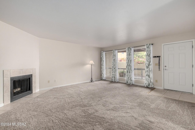 unfurnished living room featuring light colored carpet and a tiled fireplace