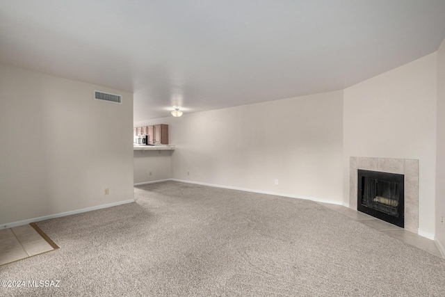 unfurnished living room featuring light carpet and a fireplace