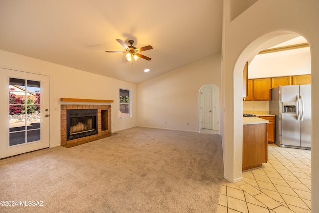 unfurnished living room featuring ceiling fan, light tile patterned floors, and a tile fireplace