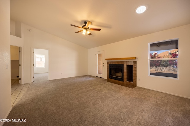 unfurnished living room featuring ceiling fan, lofted ceiling, a fireplace, and carpet floors