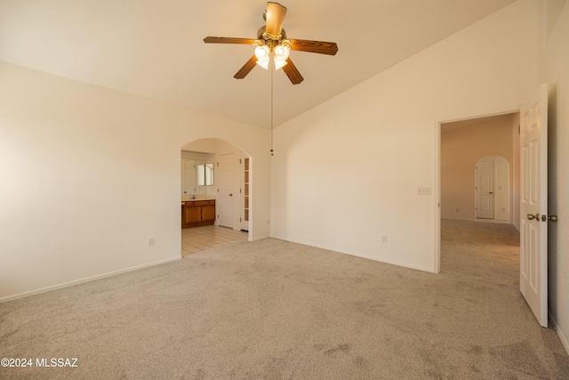 carpeted spare room featuring ceiling fan and high vaulted ceiling