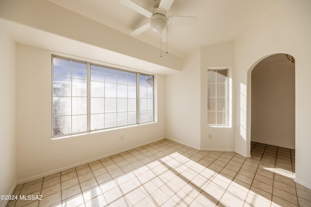 spare room with ceiling fan, light tile patterned floors, and a wealth of natural light