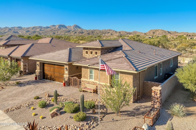 view of front of home with a mountain view and a garage