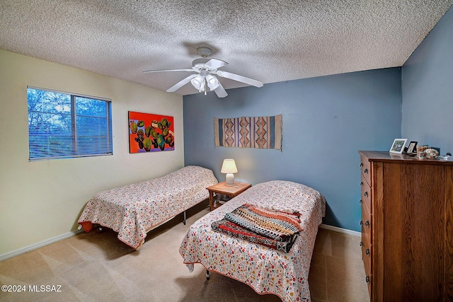 carpeted bedroom featuring a textured ceiling and ceiling fan