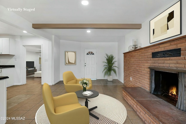 living room with a fireplace, beamed ceiling, and light tile patterned flooring