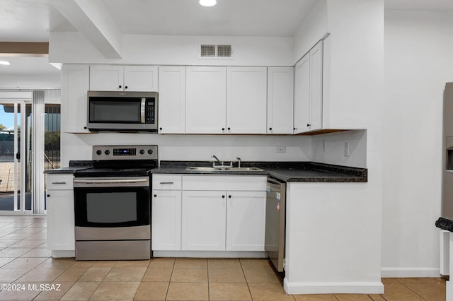 kitchen featuring white cabinets, appliances with stainless steel finishes, light tile patterned flooring, and sink