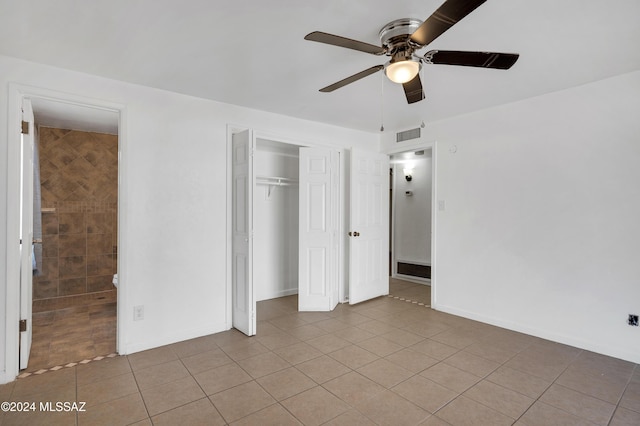 unfurnished bedroom with light tile patterned floors, a closet, and ceiling fan