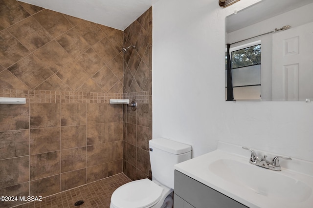 full bathroom featuring tiled shower / bath, vanity, toilet, and tile walls