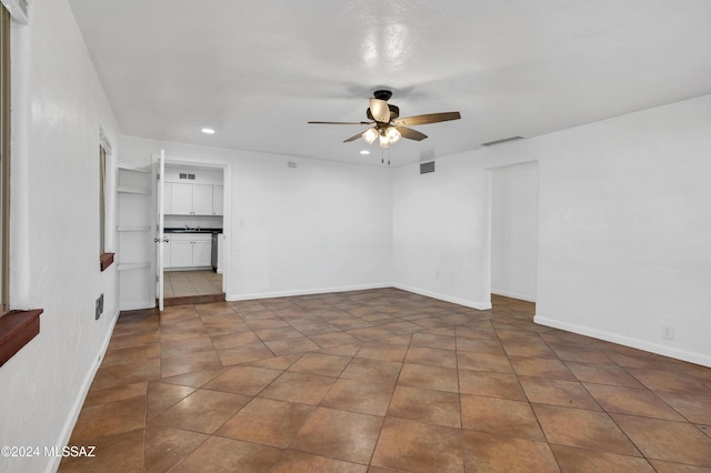 tiled spare room with ceiling fan