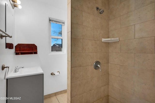 bathroom with a tile shower, tile patterned flooring, and vanity