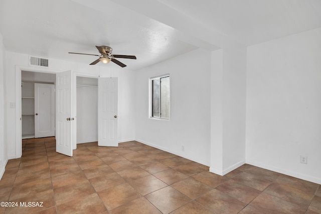 unfurnished bedroom featuring ceiling fan and a closet