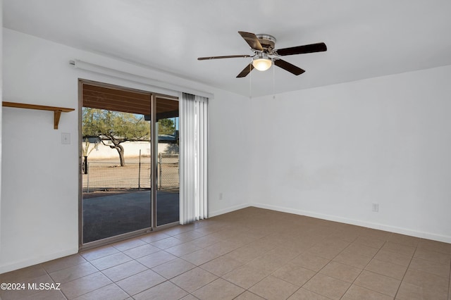 spare room with ceiling fan and light tile patterned flooring